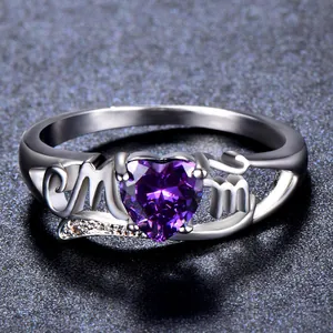 Macro shot of silver ring featuring MOM lettering and a purple heart-shaped stone