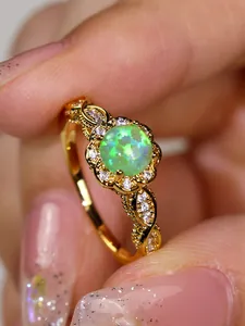 Macro shot of vintage gold flower ring featuring green opal and halo diamonds