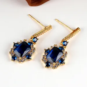 Nahaufnahme goldener Vintage-Ohrringe mit blauen rechteckigen Steinen und Zirkonia