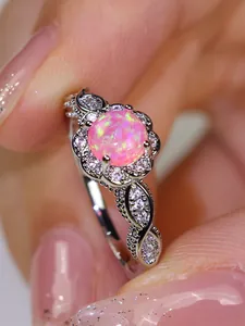 Macro detail of vintage floral ring with pink opal center and sparkling lace band