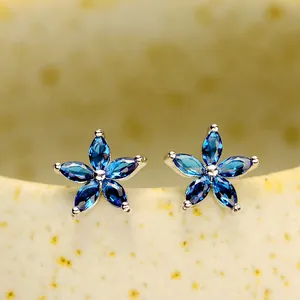 Vue détaillée de boucles d'oreilles fleur en argent avec cristaux marquise bleus