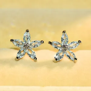 Détail macro de boucles d'oreilles fleur à cinq pétales avec zircons taille marquise