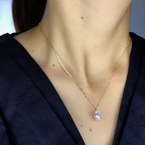 Minimalist pear-shaped zircon pendant necklace with gold chain worn on the collarbone