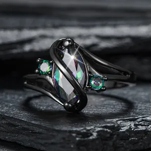 Zwartgouden ring met kleurrijke marquise edelsteen en kleine diamanten op een stenen vlak