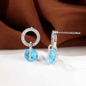 Boucles d'oreilles argentées avec zircon bleu mer et cercle de cristal sur tissu
