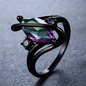 Macro-opname van zwartgouden ring met kleurrijke marquise-topaas en zijaccenten