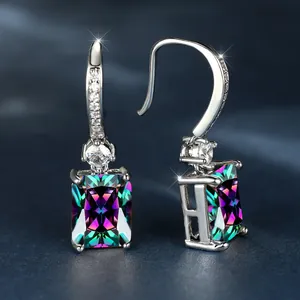 Vista macro de pendientes de plata con piedras rectangulares iridiscentes y circonitas