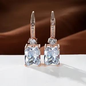Detalle de pendientes de oro rosa con circonitas rectangulares y gancho con pavé
