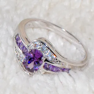 Anello con cristallo viola ovale, alone di zirconi bianchi e fascia a onde