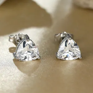 Macro shot of silver S925 triangle stud earrings with three-prong set purple zircons