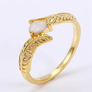 Detailed view of golden feather ring featuring a water-drop shaped opal gemstone