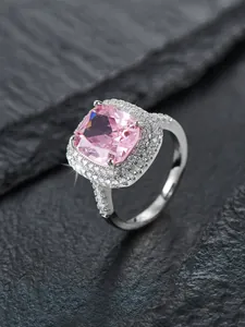 Makroaufnahme: Quadratischer rosa Edelsteinring mit Doppelhalo und Pavé-Diamantband