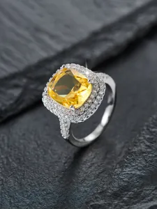 Makroaufnahme: Gelber Ring mit Kissenschliff und Diamant-Halo auf Schieferhintergrund