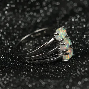 Vue latérale détaillée de la bague opale blanche à trois pierres au design noir fusil