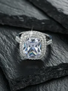 Makroaufnahme von Diamantring mit Kissenschliff und doppeltem Halo auf schwarzem Stein