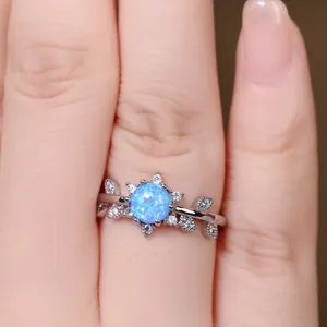 Gros plan d'une bague en argent avec opale bleue et détails en zircone cubique