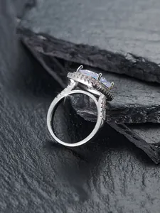 Detaillierte Nahaufnahme eines silbernen quadratischen Rings mit Mikropavé auf schwarzem Stein