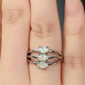 Détail d'une bague argentée avec trois opales incrustées et design ajouré élégant