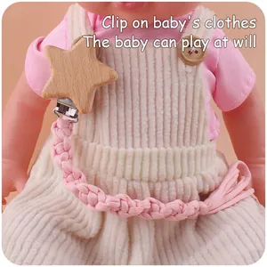 Detail von Buchenholz-Sternclip und rosa handgewebter Baumwollkette an Babykleidung