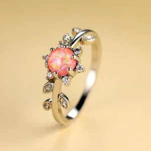 Macro d'une bague en argent avec opale rose et zircons en forme de feuilles