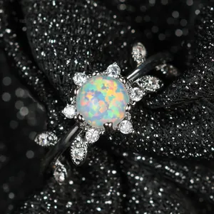 Bague feuille en argent avec opale à six griffes et zircons sur fond noir scintillant