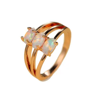 Bague trois pierres opale ovale avec anneau triple fendu en or rose sur fond blanc