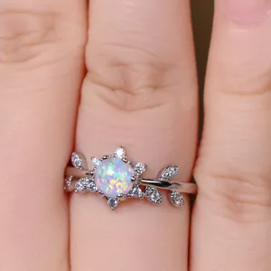 Gros plan d'une bague en argent avec opale et zircons en forme de feuille au doigt