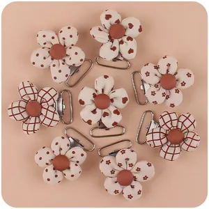 Close-up of 8 DIY floral pacifier clips with brown heart and polka dot patterns