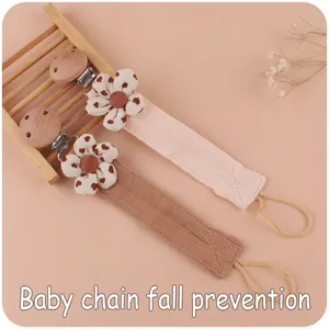Detail of fabric pacifier clips with cotton flowers and beech wood clips for infants