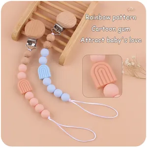 Gros plan sur l'attache-tétine en hêtre avec perles en silicone arc-en-ciel pour bébé