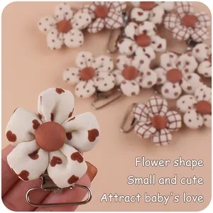 Close-up of floral fabric pacifier clips with heart, plaid, and polka dot patterns