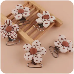 Close-up of five fabric floral pacifier clips with various patterns and metal clasps