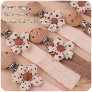Detailed view of floral cotton pacifier clips with beech wood and metal fasteners