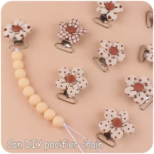 Close-up of DIY pacifier clips with floral fabric patterns and silicone bead chain