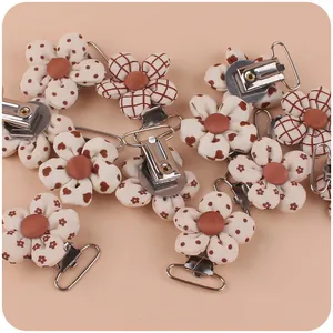 Detail of floral fabric pacifier clips with vintage patterns and silver metal fasteners
