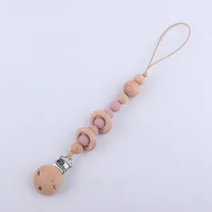 Détail de l'attache-tétine avec anneaux en bois de hêtre et perles en silicone rose