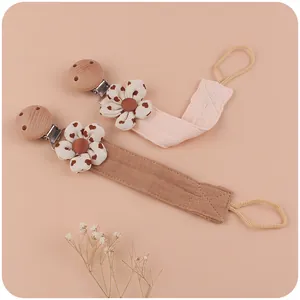 Handmade beech wood pacifier clip with cotton linen floral straps in pink and brown