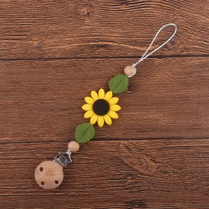 Détail de l'attache-tétine en hêtre avec fleur de tournesol en silicone souple