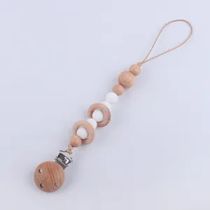 Détail de l'attache-tétine en bois de hêtre avec perles en silicone blanc pour bébé