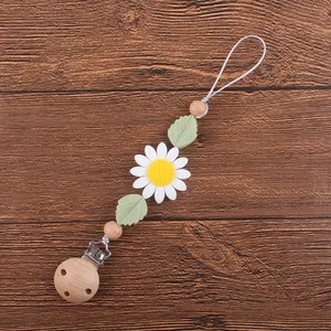Détail d'une attache-tétine en silicone marguerite avec perles en bois de hêtre naturel