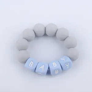Macro detail of silicone baby teether bracelet with grey beads and blue BABY letters