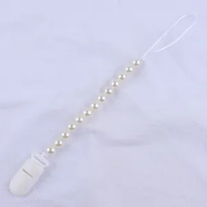 Close-up of baby pacifier clip with cream imitation pearls and durable white plastic buckle