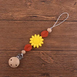 Détail de l'attache-tétine bébé avec tournesol en silicone jaune et clip en bois de hêtre