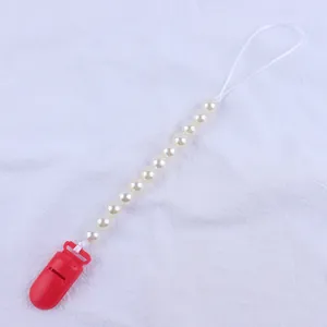 Close-up of baby pacifier clip with red plastic clasp and round cream pearl beads