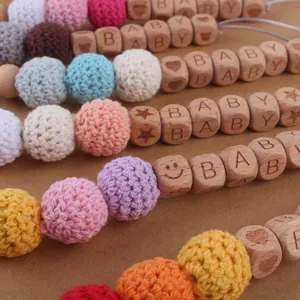 Attache-tétine colorée en boules de laine crochetée et perles de bois gravées pour bébé