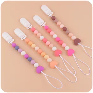 Dettaglio di catenelle portaciuccio in silicone con perline a cuore in cinque varianti colore