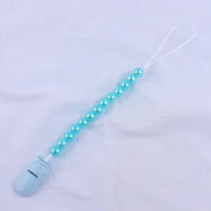 Close-up of light blue baby pacifier clip with shiny imitation pearl plastic beads