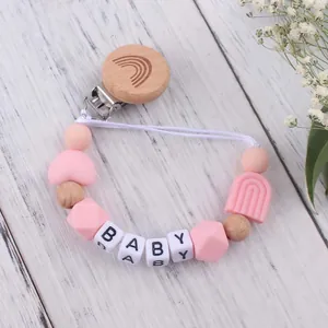 Detail von rosa Silikonperlen und Holzclip mit Regenbogen-Gravur für Baby Schnullerkette