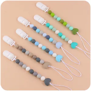 Dettaglio di catenelle per ciuccio in silicone con perline a cuore in cinque colori