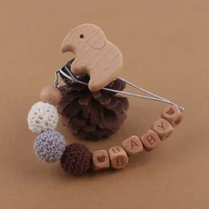 Détail de l'attache-tétine bébé avec éléphant en bois, perles crochet et gravure BABY